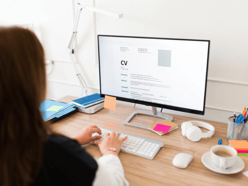 A woman seen from behind working on her CV