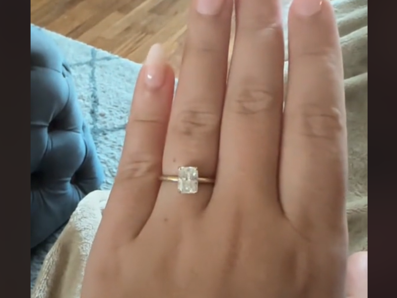 A woman shows off her hand with her engagement ring