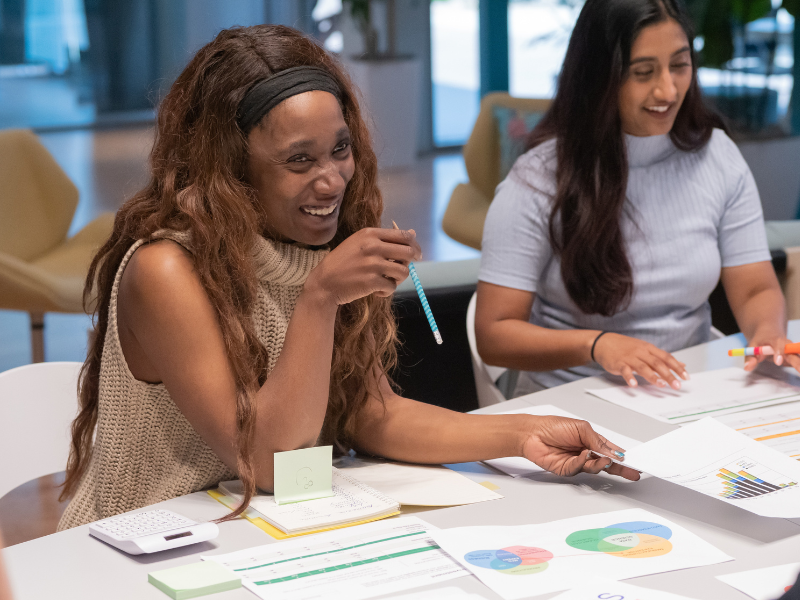 A woman smiling with her work colleagues in office