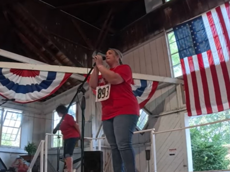 A woman standing on a stage talking on a microphone