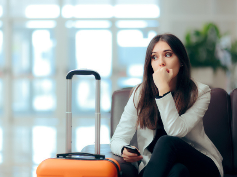 A woman waiting with her suitcase at the airport