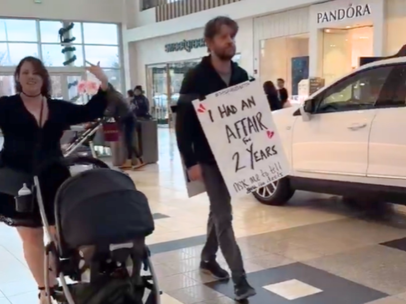 A woman walking with a stroller and her cheating husband in the mall