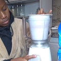 A woman washes clothes using a blender