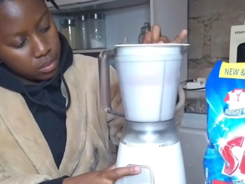 A woman washes clothes using a blender