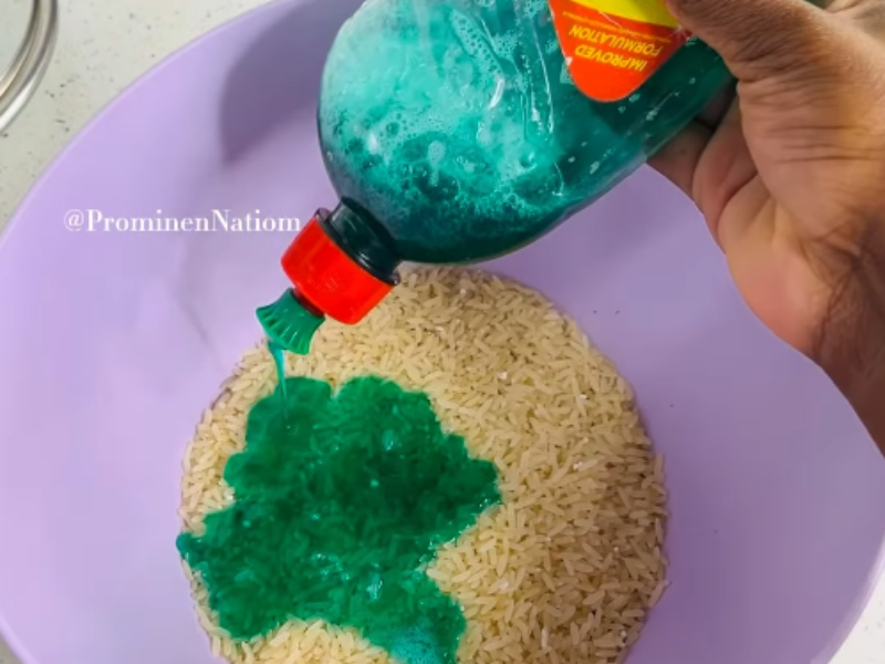 A woman washes uncooked rice in a bowl using dishwashing liquid