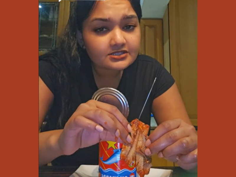 A woman with an open can of Lucky Star Tin Fish
