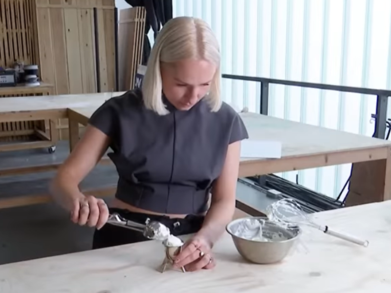 A woman with blonde hair mixing ice cream on counter top