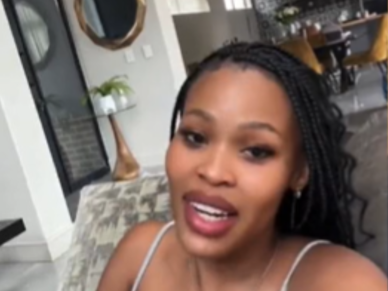 A woman with braids seated in her lounge