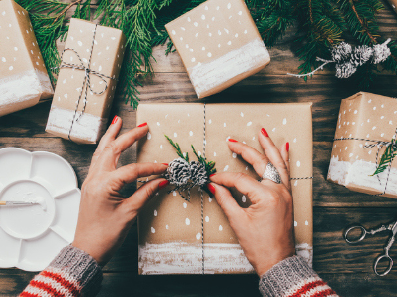 A woman wrapping Christmas presents in a crafty way
