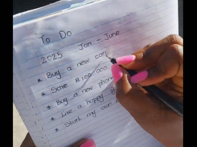 A woman writes her goals on a note pad
