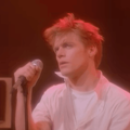 A young Bryan Adams performing on stage