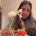 A young Indian woman holds up a basket wedding invitation
