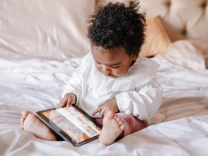 A young baby watching something on a smart device
