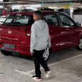 A young boy walking toward a new car parked inside carpark