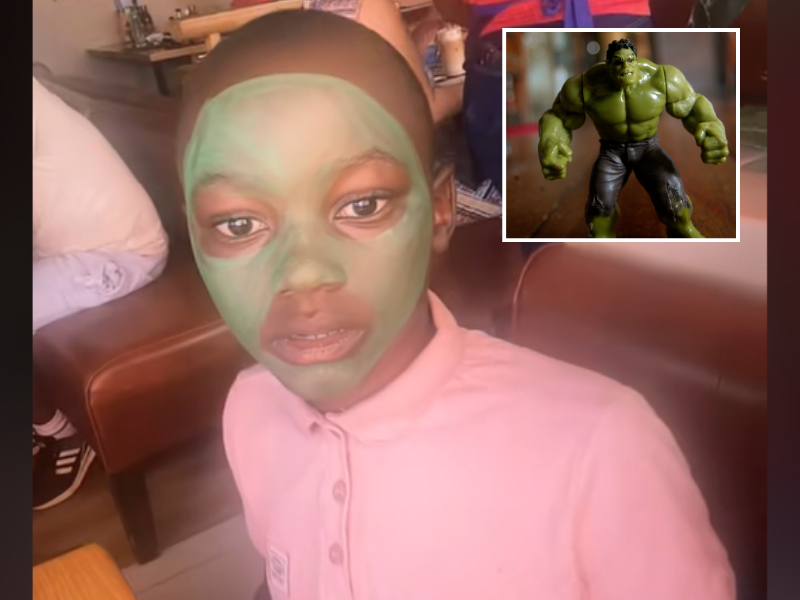 A young boy has his face painted green