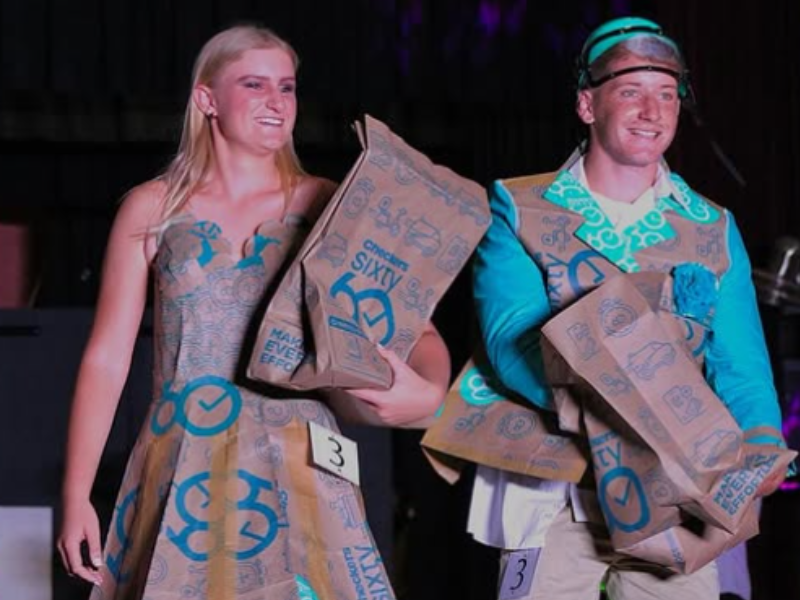 A young couple wearing outfits made out of Checkers Sixty60 shopping bags