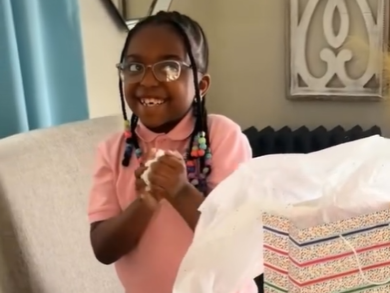A young girl with braided hair wearing spectacles