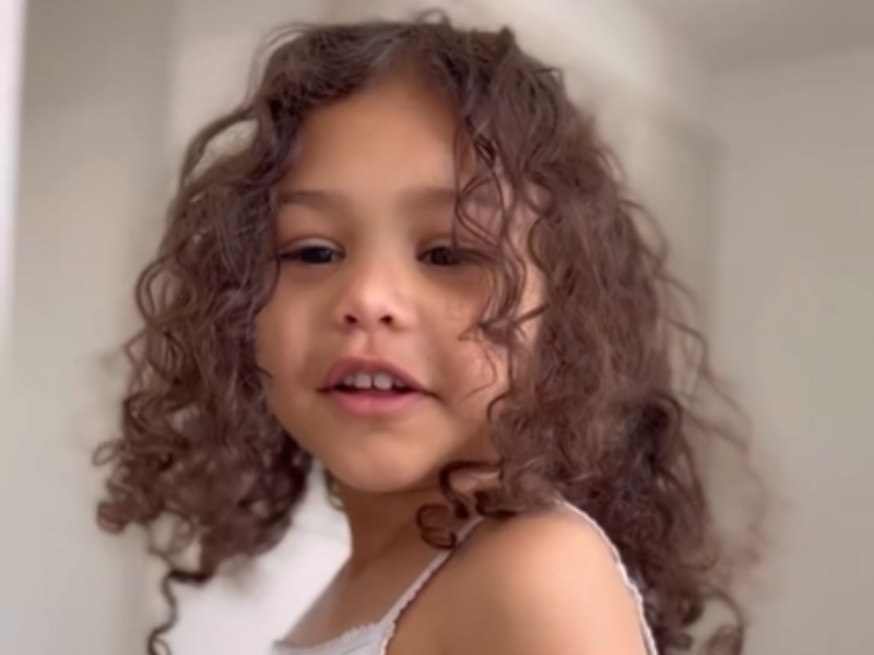 A young girl with curly long hair