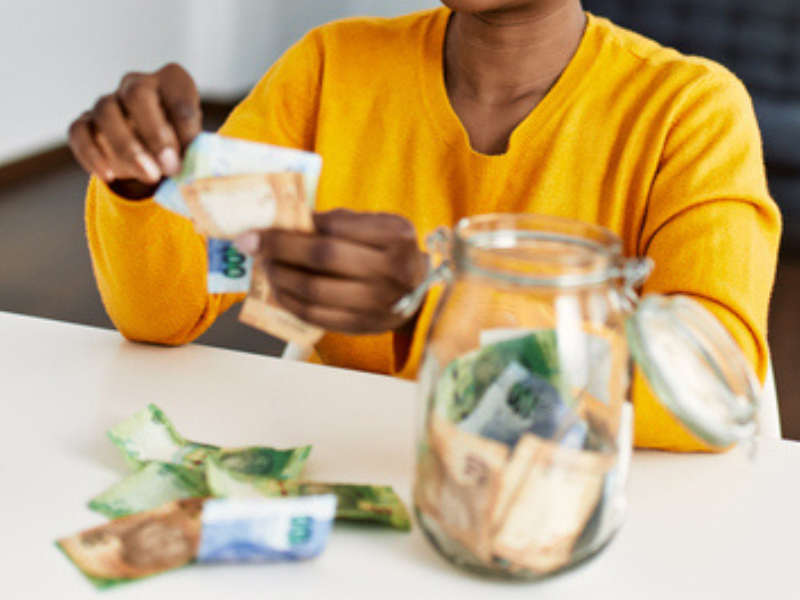 African woman sitting at a table holding Rands