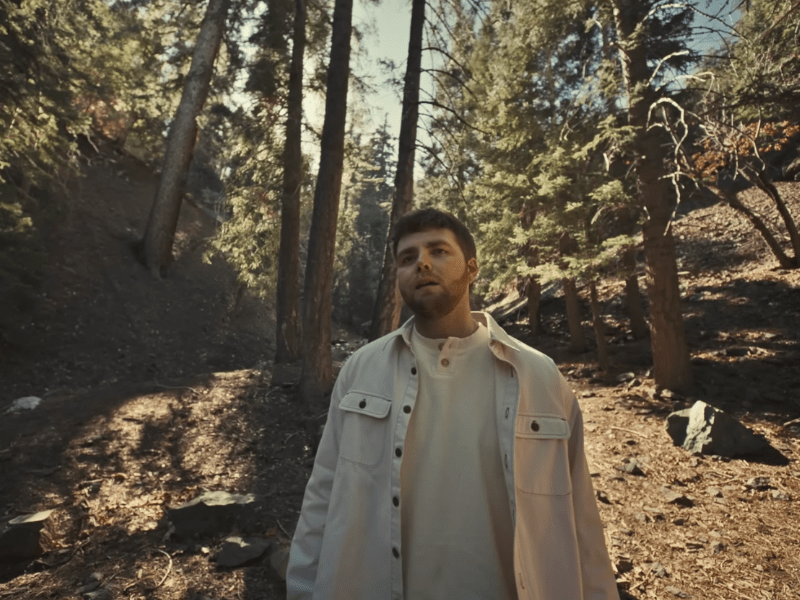 Alex Warren walks through a forest