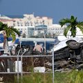 Officials investigate the scene where cars were damaged after a Prime Air cargo plane crashed