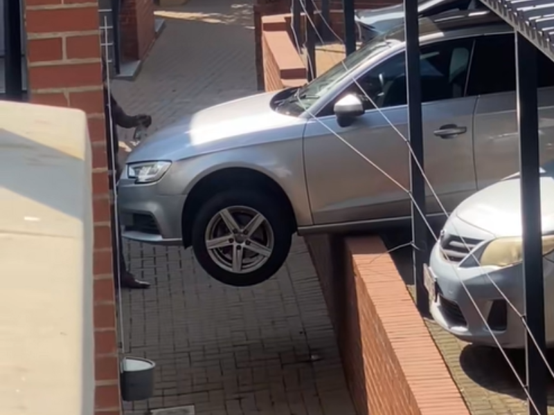 An Audi vehicle hangs off the side of a wall over the parking bay