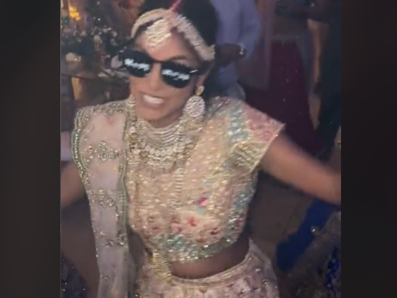 An Indian bride wears sunglasses and dances