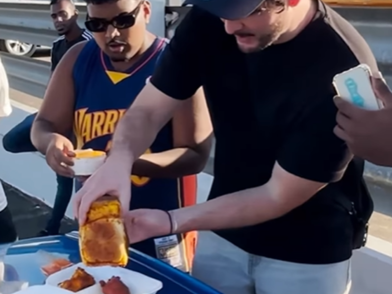 An Indian guy looks shocked as his white friend empties out a bunny chow