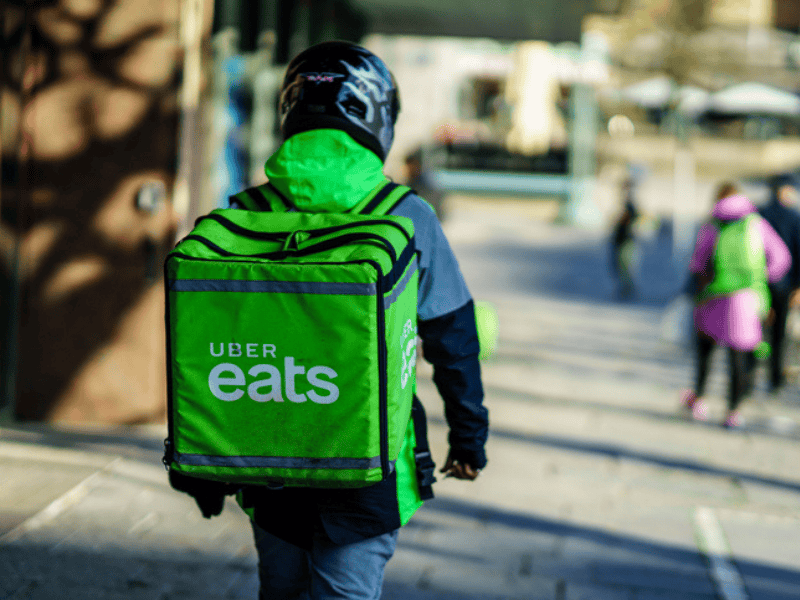 An Uber Eats delivery person carrying food to people