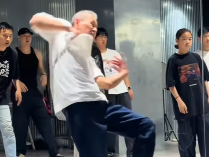 An elderly man shows off his dance moves inside a dance studio