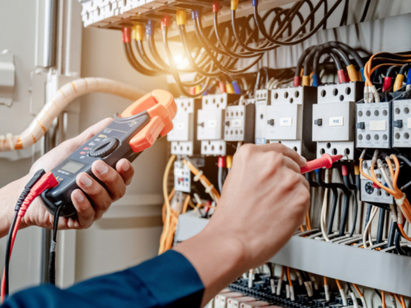 An electrician engineer uses a multimeter to test the electrical installation