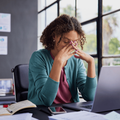 An woman looks stressed at her workplace