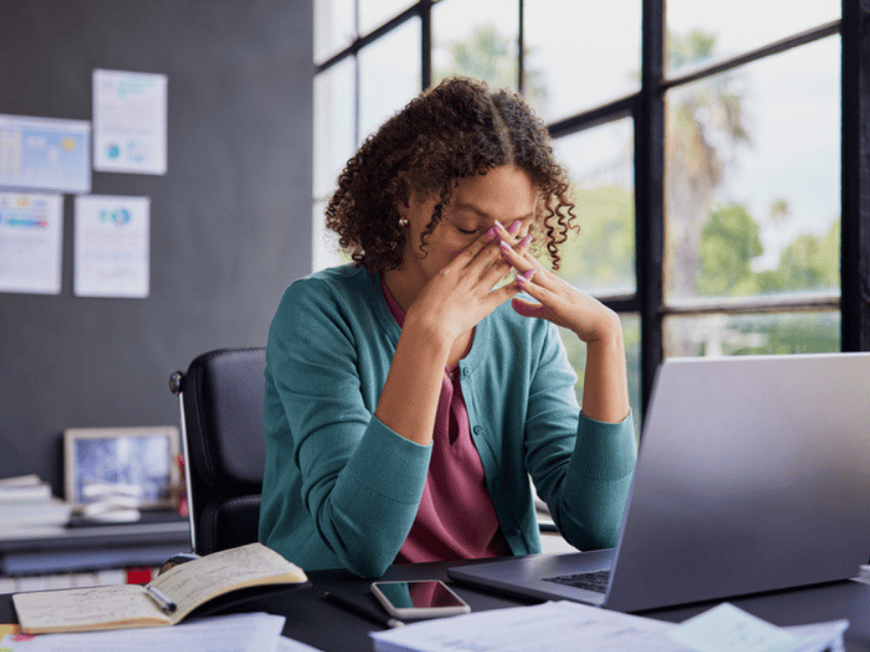 An woman looks stressed at her workplace