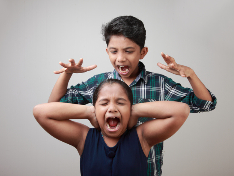 Angry elder brother screaming at his younger sister