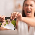 Angry woman tears up picture of couple