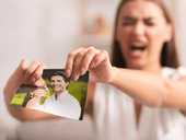 Angry woman tears up picture of couple