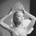 Ariana Grande lifting a tiara above her head