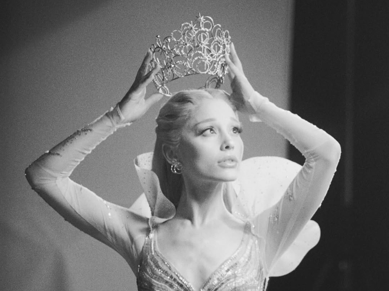 Ariana Grande lifting a tiara above her head