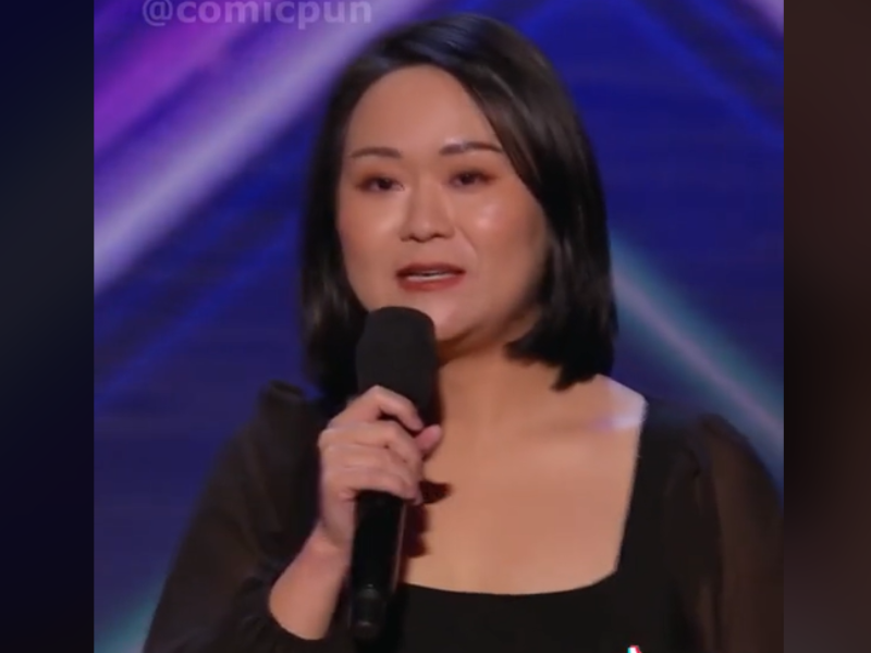 Asian woman talking with a mic on stage