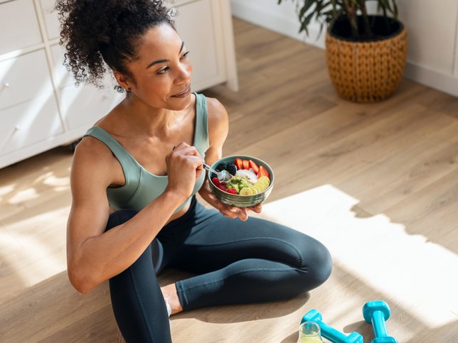 Athletic woman eating a healthy fruit bowl