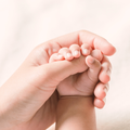 Baby holding mom's thumb