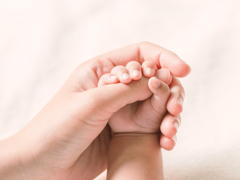 Baby holding mom's thumb