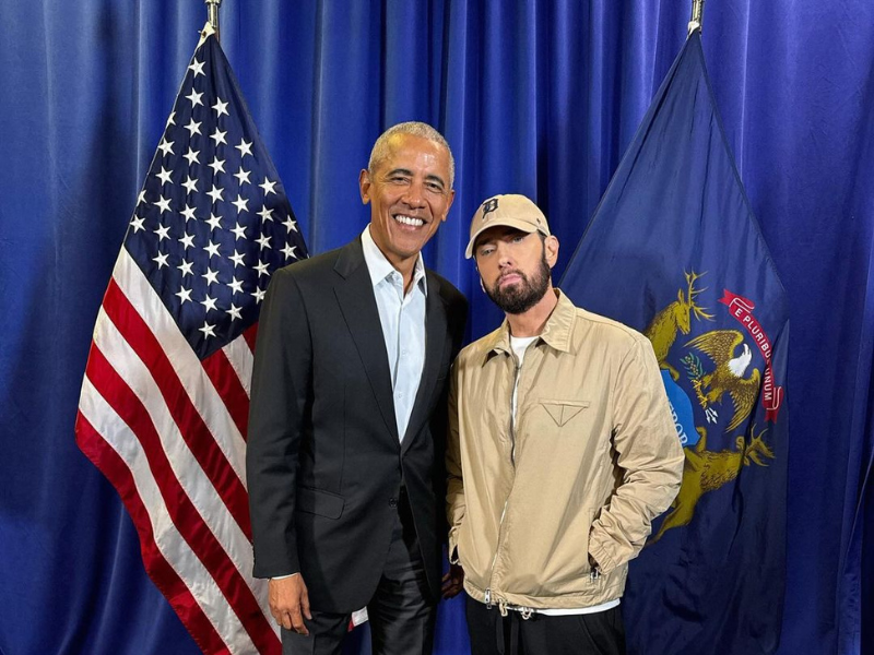 Barack Obama and Eminem pose in front of an American flag