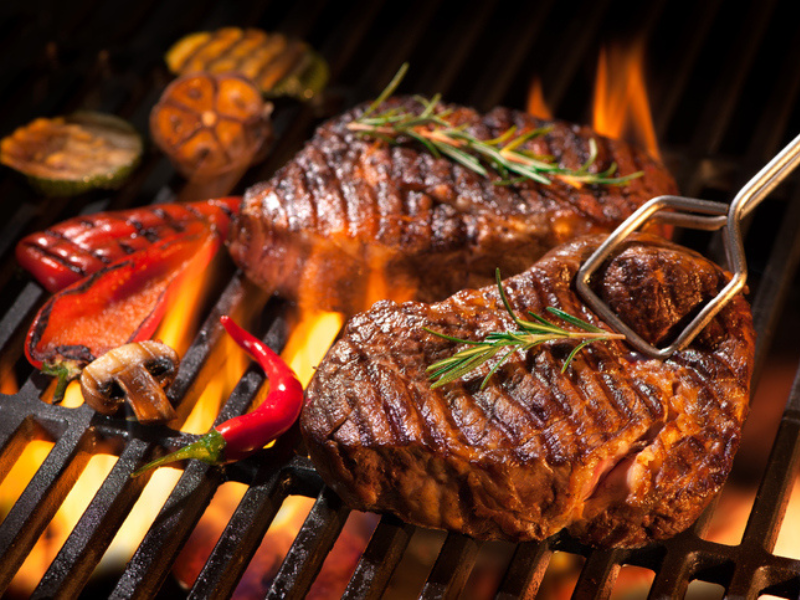 Beef steaks on the braai with flames