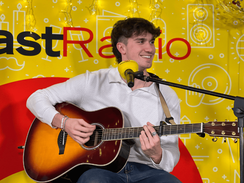 Ben Rodrigues playing his guitar at East Coast Radio