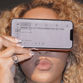 Beyonce covers her eyes with an iPhone