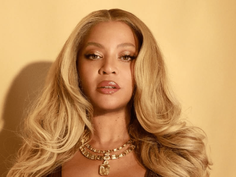 Beyoncé wearing a layered gold necklace with with a big pendant