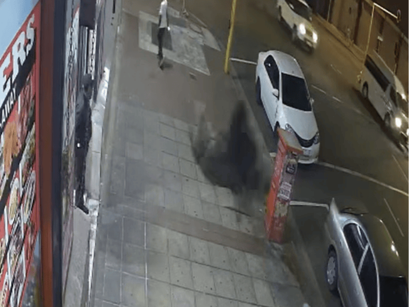 Black smoke comes from from the ground on a Durban sidewalk
