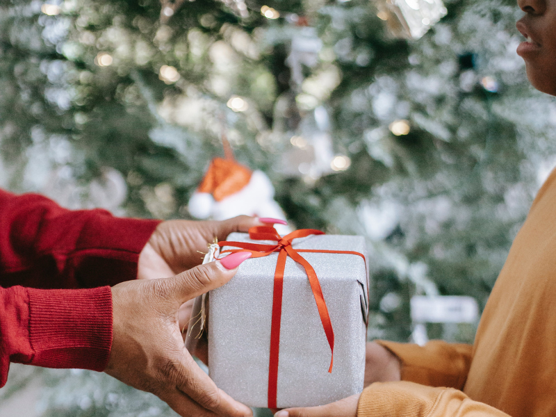 Black woman giving a gift to a kid