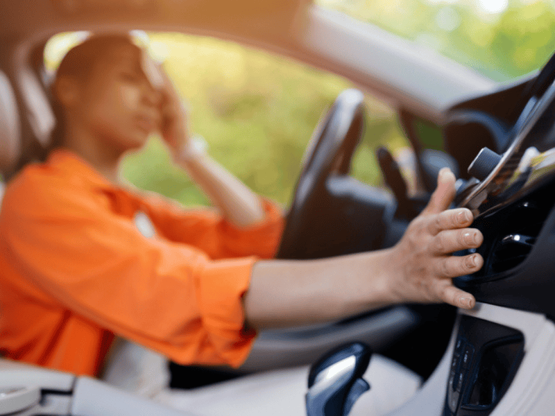 Black woman in car stressed by the heat